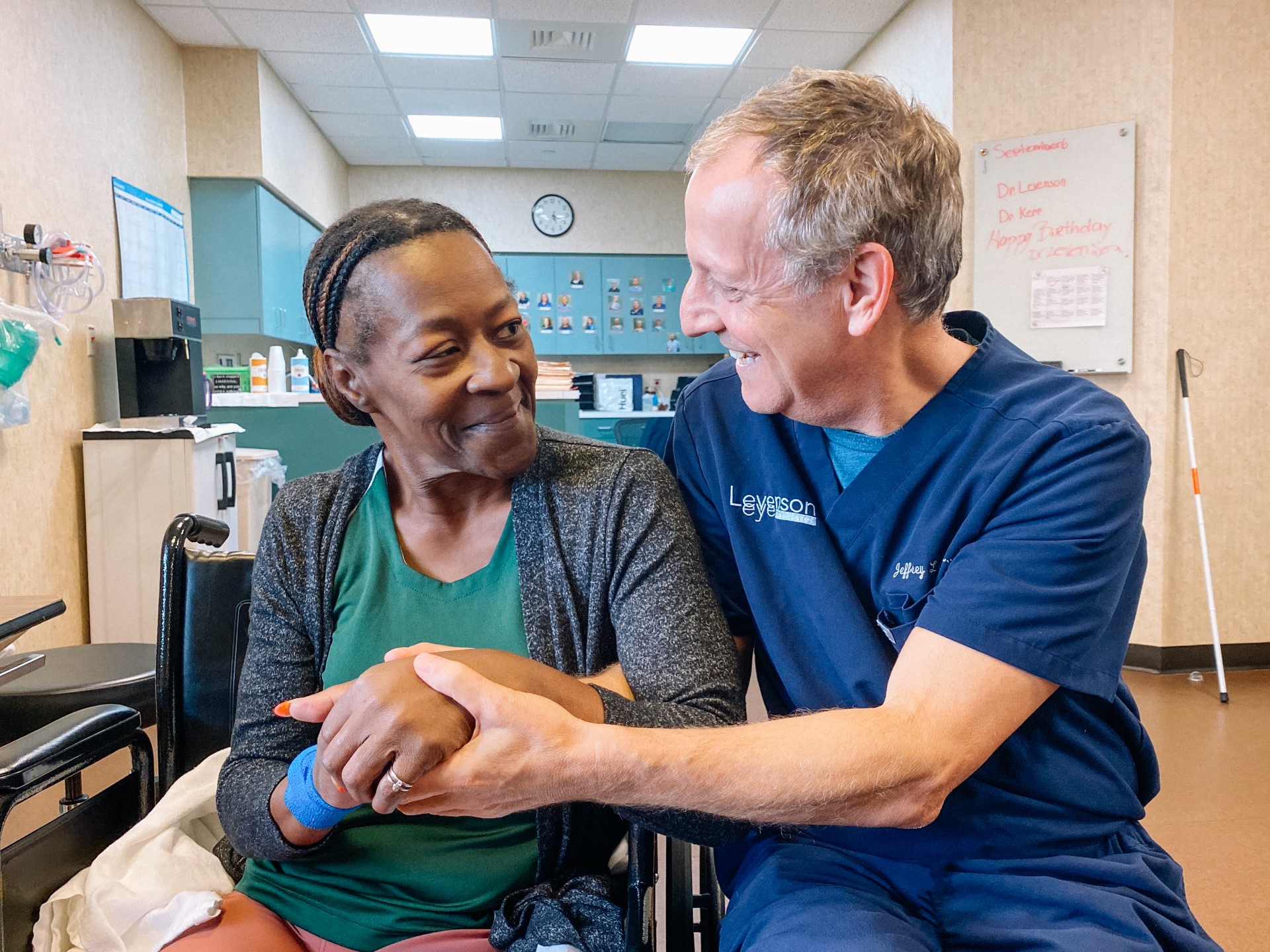 Surgeon and patient sitting together smiling.